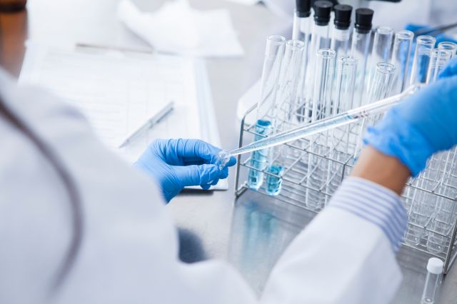 試験管に液体を移す医師